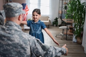 soldier father embracing daughter at home