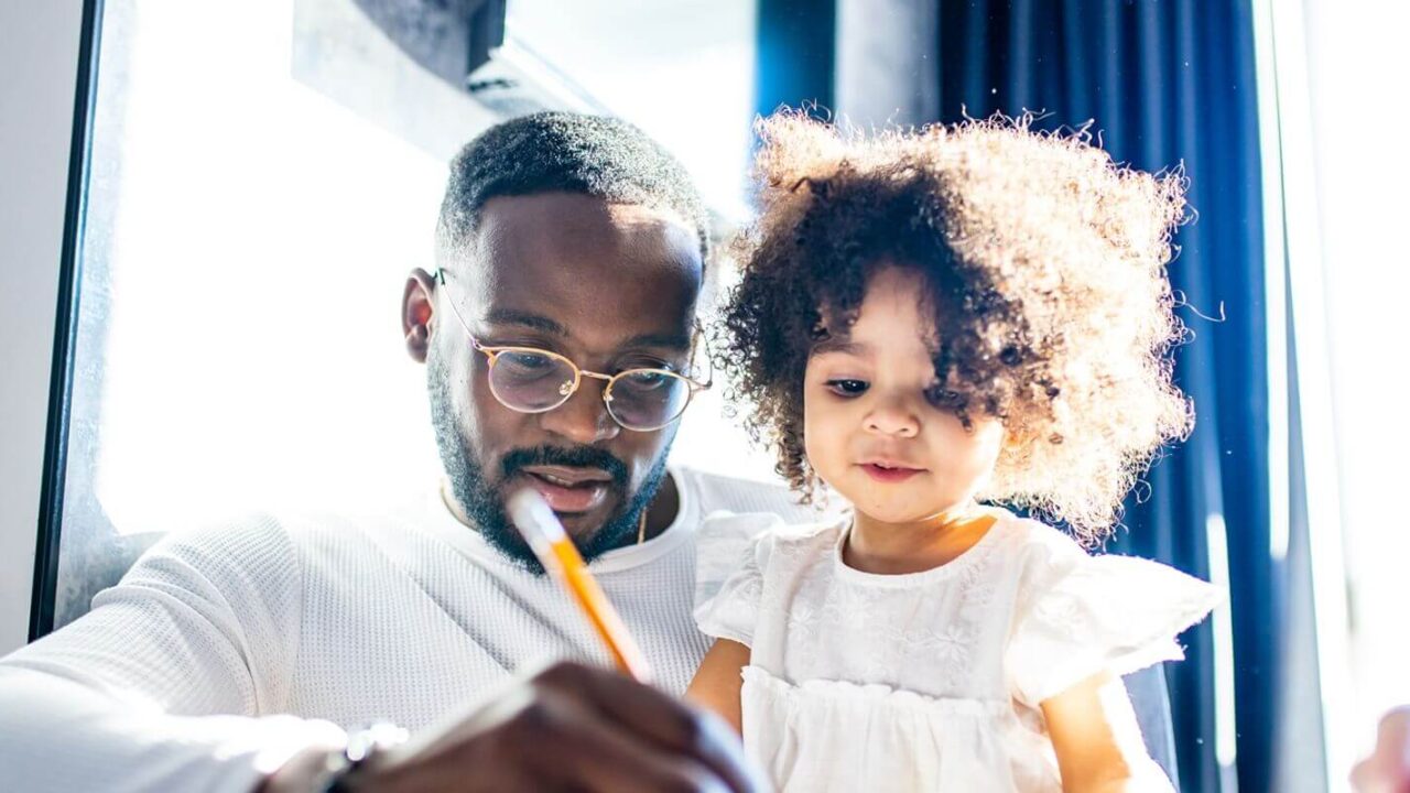 authentic bearded father and baby girl are painting draw on table day light background