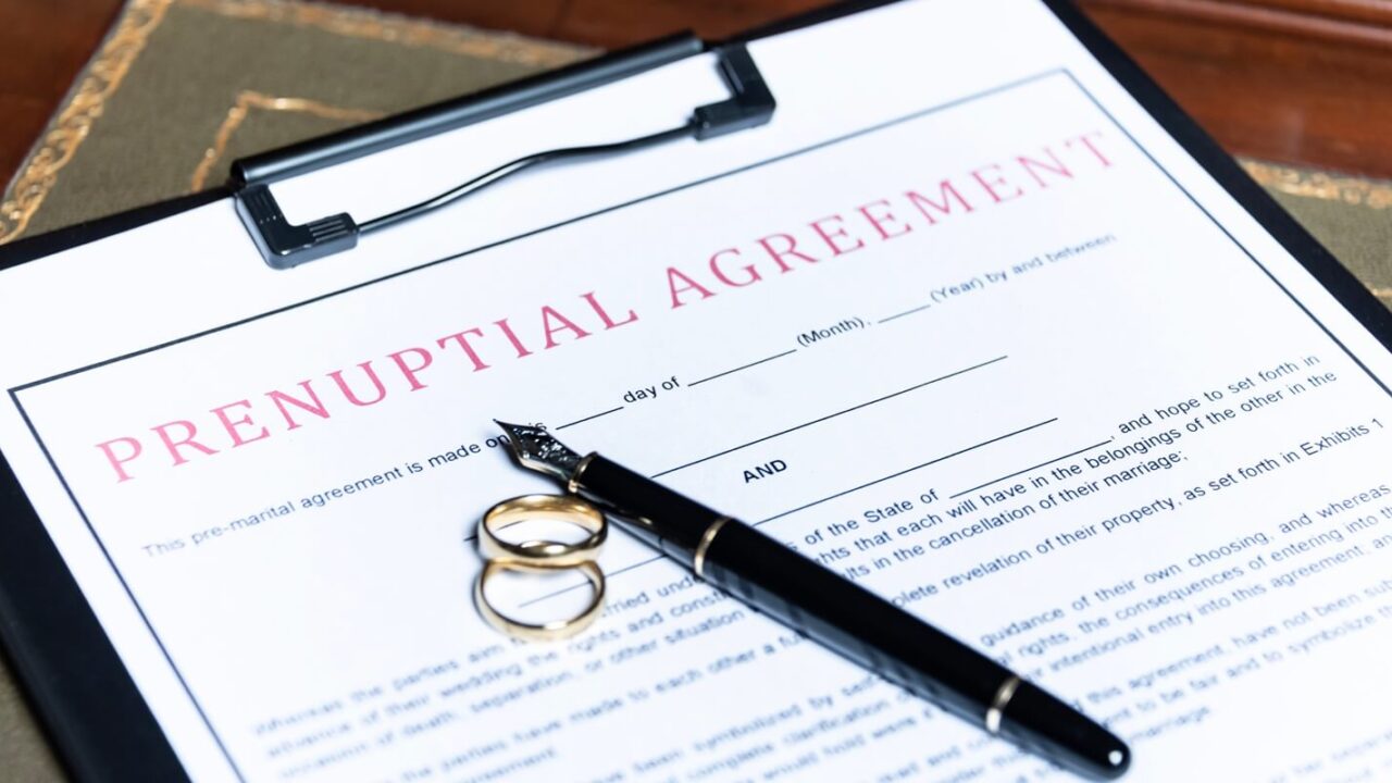 close-up of a prenuptial agreement form with wedding rings and a fountain pen