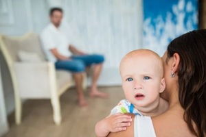 young woman holds a small child in her arms amid a tired