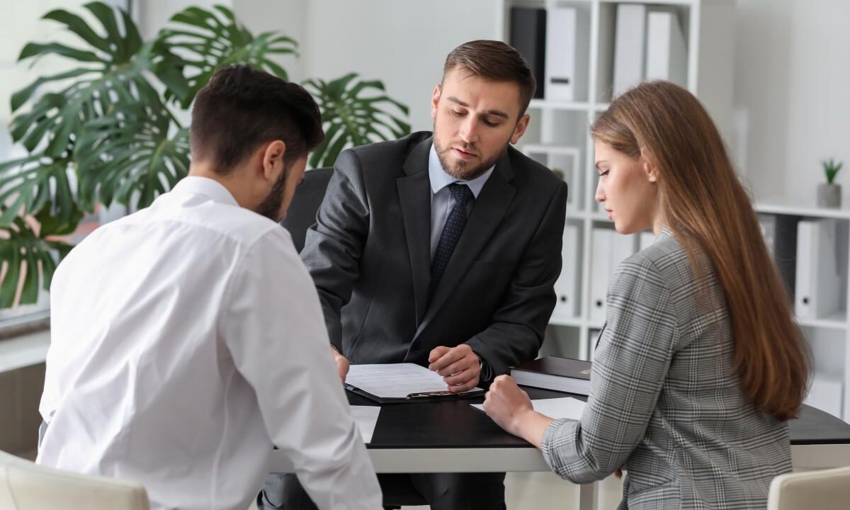 Unhappy young couple visiting divorce lawyer in office