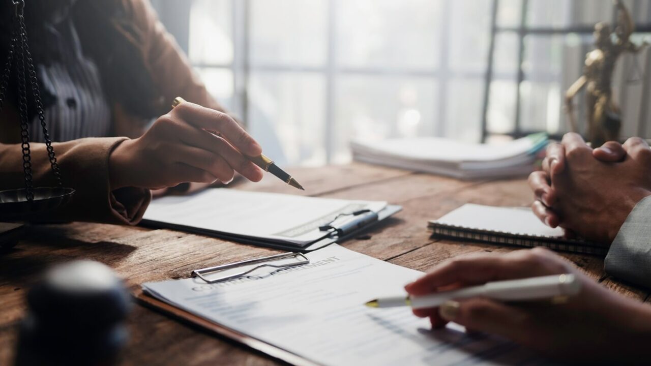 lawyers and clients engaging in a detailed discussion about contract specifics during a focused meeting in a professional law office