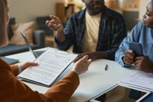 woman holding clipboard consulting family in therapy session or insurance agency copy space