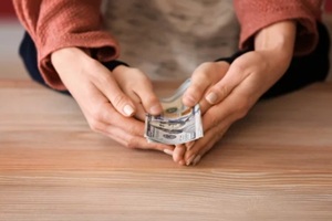 woman with his son holding dollar banknotes on wooden table