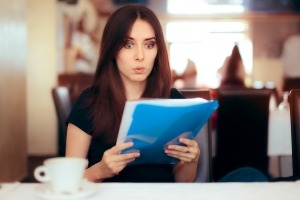 Shocked Woman Reading Divorce Papers Sent from Her Spouse
