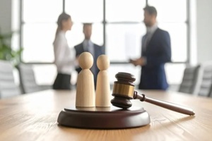 family wooden figures with judge gavel in courtroom