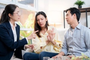 asian couple arguing with therapist during home consultation