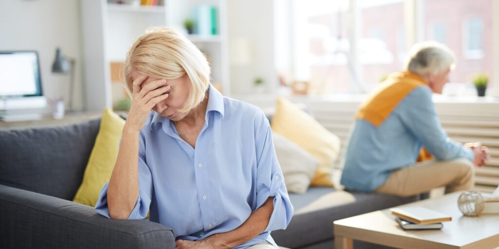 portrait of modern senior couple fighting focus on frustrated senior woman in foreground, copy space