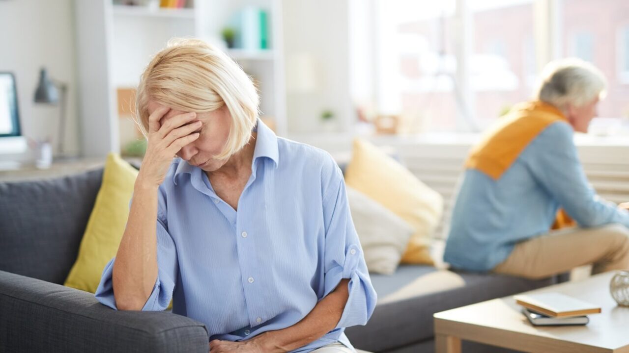 portrait of modern senior couple fighting focus on frustrated senior woman in foreground, copy space