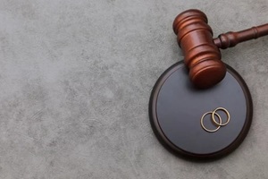 judge gavel wedding rings on concrete stone grey background