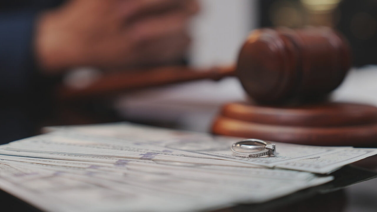 dramatic, selective-focus close-up shot of a wooden judge's gavel being struck down onto its sound block