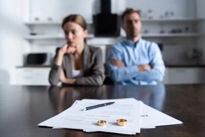 selective focus of couple sitting at table with divorce documents